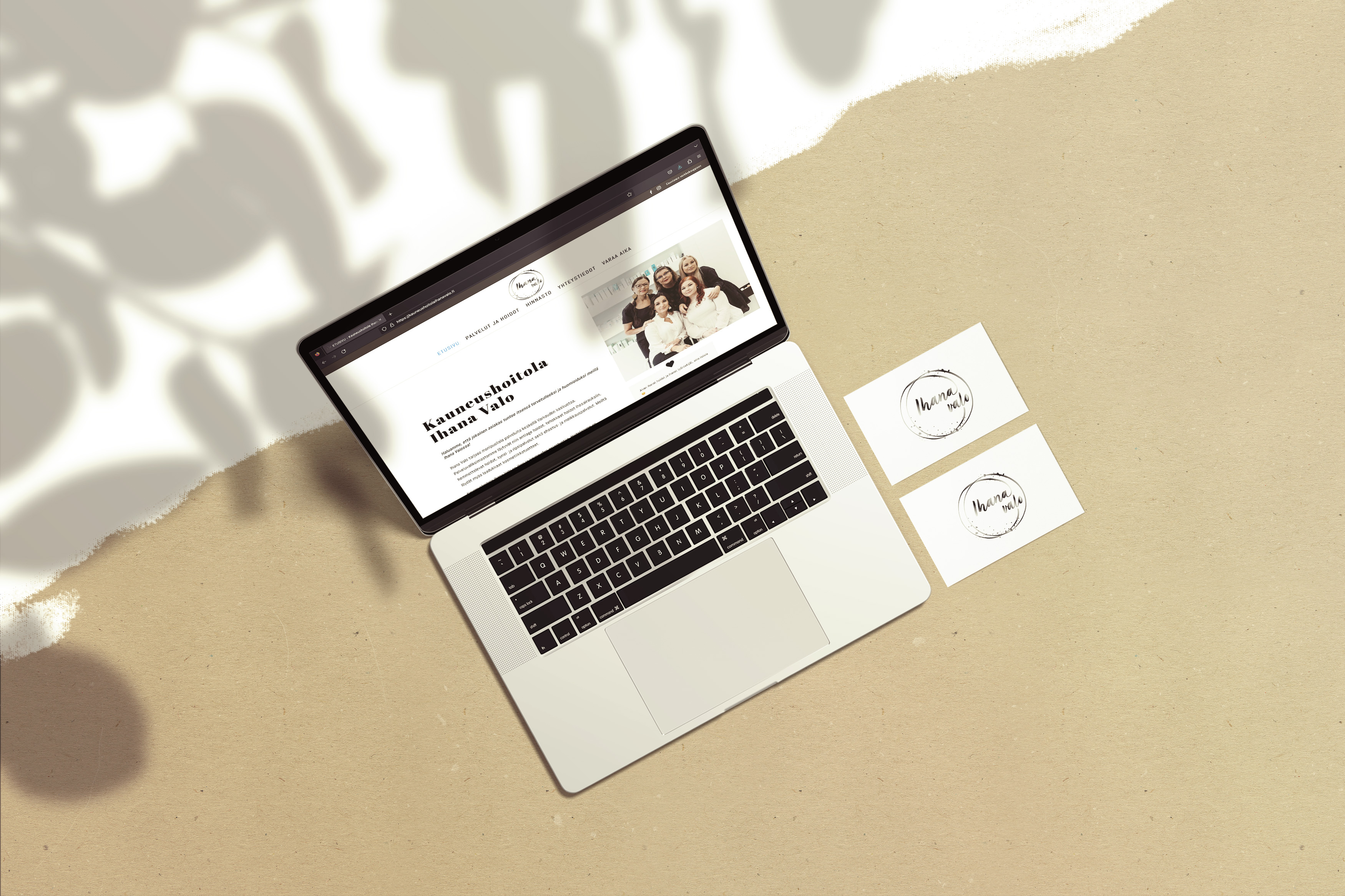 The website of Ihana Valo Oy opened on a laptop, along with two business cards